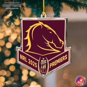 A Brisbane Broncos 2025 NRL Premiers acrylic ornament hanging from a Christmas tree with warm bokeh lights in the background.