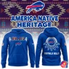 Front and back views of a royal blue Buffalo Bills hoodie with Native-inspired patterned "BILLS" lettering and feather accents on the chest, team logo on the front, and a circular feather motif with "BUFFALO BILLS" text on the back set against a southwestern geometric background