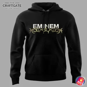 Close-up of the front of the black Eminem hoodie showing the Eminem logo above a gold and black tribal graphic design.