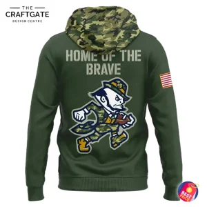 Back view of the olive-green camo hoodie displaying "HOME OF THE BRAVE" text and a running Notre Dame mascot, with American flag patch on the sleeve.