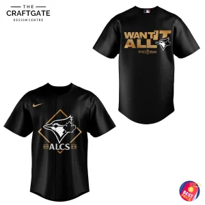 Isolated product image of black Toronto Blue Jays ALCS jersey on white background, front view shows diamond Blue Jays logo, "ALCS" text and gold Nike swoosh, back view shows large gold "WANT IT ALL" Postseason graphic with team logo.